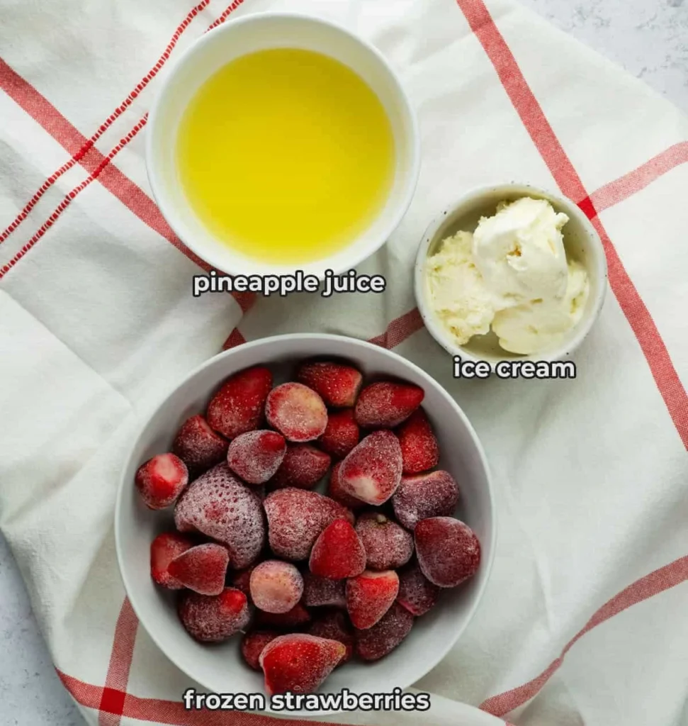 Top view of frozen strawberries, pineapple juice, and vanilla ice cream on a white towel with red stripes